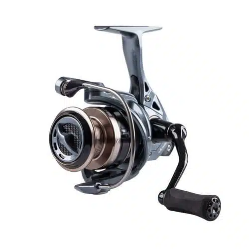 Un primer plano del carrete de pesca Carrete Okuma Epixor EPXT-55 resalta su cuerpo metálico adornado con detalles en negro y plata. La manija está ubicada en el lado derecho y la bobina muestra detalles de diseño intrincados. Este carrete bien elaborado rezuma sofisticación y calidad.
