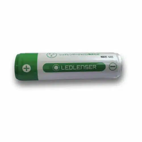 La imagen muestra una batería cilíndrica con un esquema de colores verde y blanco. El extremo verde, marcado con un signo más, indica el terminal positivo. La palabra "Ledlenser" está impresa en el lateral junto con texto y símbolos adicionales, que la identifican como una Batería Led Lenser Li-Ion 18650 3000mAh.