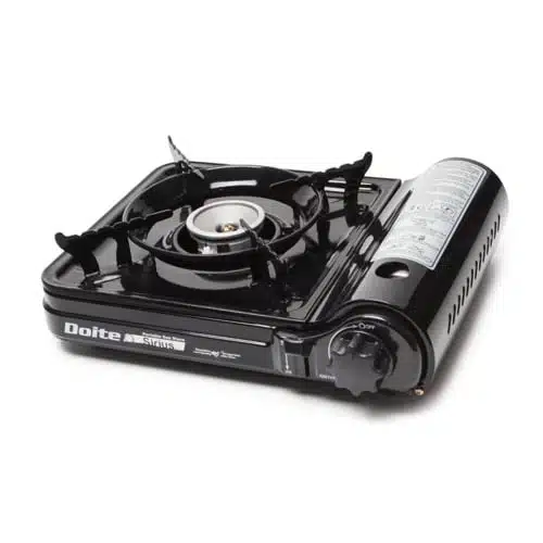 Imagen de la cocina portátil para acampar Cocinilla Sirius Doite, de color negro, con un solo quemador y un compartimento lateral para una bombona de gas. La marca "Doite" se muestra de forma destacada en el frente. Esta cocina cuenta con un dial de encendido y cuatro soportes para ollas que rodean el quemador para garantizar la estabilidad de los utensilios de cocina.