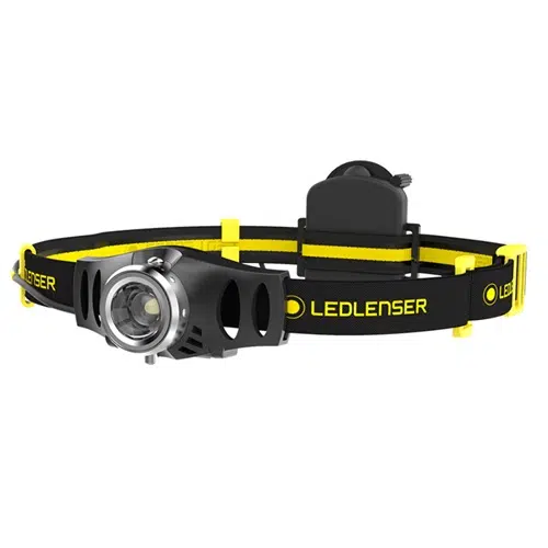 La Linterna Frontal Led Lenser IH3 120lm es una linterna frontal LED negra y amarilla con la marca "LEDLENSER" en su correa ajustable. Cuenta con una luz LED central alojada en una carcasa metálica con orificios de ventilación y la batería ubicada en la parte posterior de la correa.