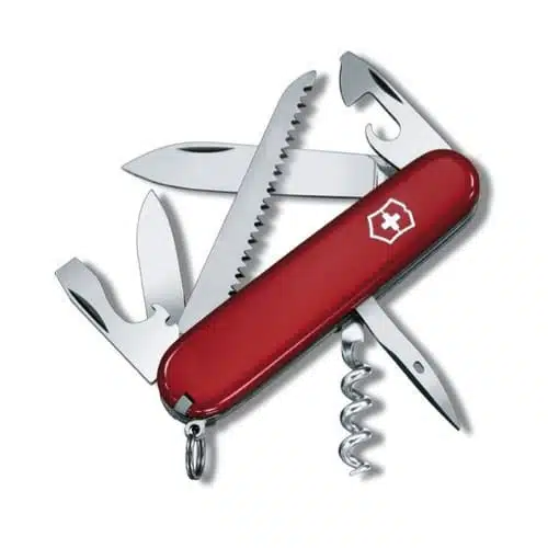 La Cortapluma Victorinox Camper Roja 1.3613 es una navaja suiza roja que incluye varias herramientas, como una hoja de cuchillo, una sierra, un abrebotellas, un abrelatas, un sacacorchos y un pequeño destornillador. Tiene un logotipo de cruz blanca en el mango y viene con un llavero en un extremo.
