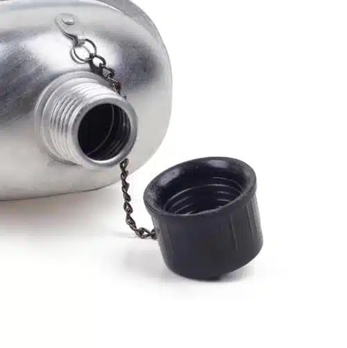 En primer plano de la cantimplora metálica Zlip 12h101 de 1,35 litros se aprecia su cuello abierto y roscado. El tapón negro, asegurado con una cadena, está colocado cuidadosamente en la parte delantera.