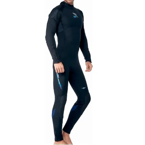 Una persona lleva el Traje De Agua Ist Ws80 Neopreno 3mm, un traje de neopreno negro de cuerpo entero con detalles en azul. El traje cubre a la persona desde el cuello hasta los tobillos y parece estar diseñado para actividades acuáticas como el buceo o el surf. La persona está descalza y mira a la cámara en ángulo.