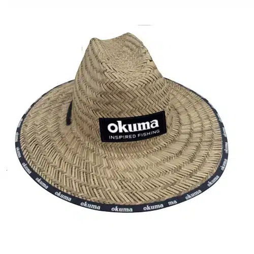 Se muestra el Gorro Okuma Paja Con Logo #Pa01c014b, que presenta un ala ancha y una banda negra alrededor del borde adornada con la palabra "okuma" repetidamente en texto blanco. La parte delantera de este sombrero de paja incluye un parche negro rectangular con el texto blanco "okuma INSPIRED FISHING".