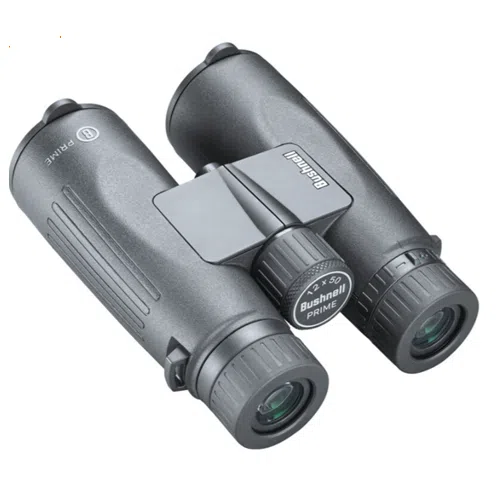 Los elegantes binoculares negros Prime 12x50 de Bushnell vienen con un agarre texturizado y oculares ajustables. Estos binoculares, que llevan la marca "Bushnell" de forma destacada, presentan un diseño contemporáneo ideal para aventuras al aire libre.