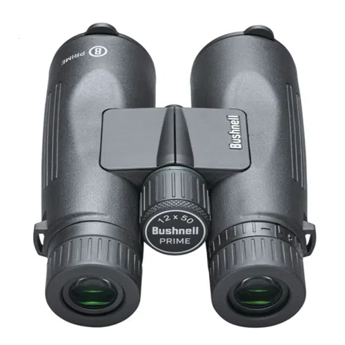 Primer plano de un par de binoculares Prime 12x50 de Bushnell con un elegante acabado negro. El ocular y los lentes objetivos son claramente visibles, con la inscripción "12x50 PRIME" elegantemente etiquetada en la perilla de enfoque central. El icónico logotipo de Bushnell adorna el puente que conecta los dos cuerpos.