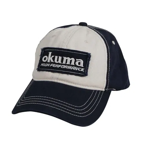 La gorra Gorro Okuma PA01C007B es una gorra de béisbol de color beige y azul marino, que presenta el logotipo "Okuma High Performance" bordado en blanco en un parche rectangular oscuro en el frente, complementado con costuras blancas en contraste a lo largo de las costuras y el ala.