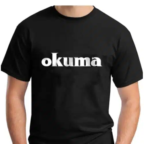 Una persona lleva la Polera Okuma Motif M/Corta, que lleva impresa la palabra "okuma" en letras minúsculas blancas y negritas en el pecho. El fondo es blanco liso. La persona no es totalmente visible; solo se ven el torso y parte de los brazos, lo que crea un motivo llamativo en contraste con la sencillez del fondo.