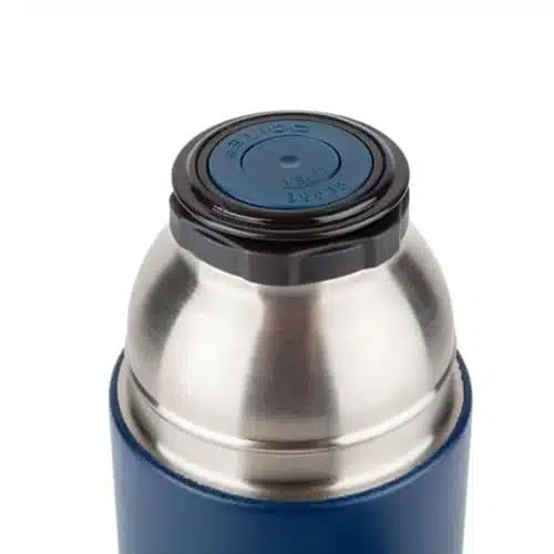 Primer plano de un termo Doite Max de acero inoxidable y color azul, con tapa de plástico negra y parte superior azul con texto grabado. El termo presenta un diseño cilíndrico y liso.