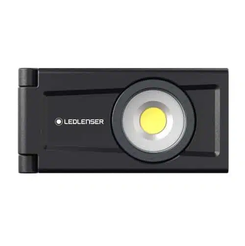 La Linterna Led Lenser iF3R Recargable 1000 Lum 502171 es una linterna LED rectangular de color negro con la marca "Ledlenser" impresa en el lado izquierdo. Cuenta con una bombilla LED circular central como fuente de luz y tiene una bisagra en el lado izquierdo, lo que indica que puede plegarse o girar, lo que mejora su versatilidad.