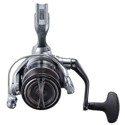 Primer plano del carrete de pesca Shimano Nasci plateado y negro, con un mango ergonómico y un intrincado mecanismo de enrollado de hilo. Su diseño elegante y moderno resalta la artesanía y la funcionalidad del carrete.