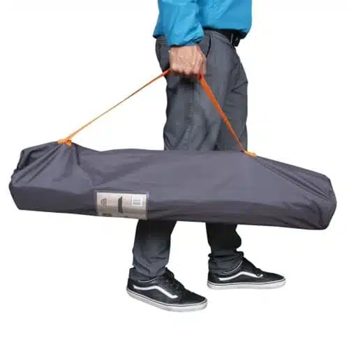 Una persona con pantalones grises y zapatillas negras lleva un bolso Doite Jalki #59526, que presenta un elegante diseño de rectángulo gris con un llamativo asa naranja.