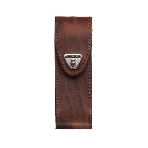 La Funda Victorinox Cuero Café es una funda de cuero marrón para navajas con borde cosido y cierre de solapa. La solapa muestra un logotipo y un botón de Victorinox en color plateado. Esta funda de cuero tiene un acabado texturizado y está diseñada para guardar de forma segura una navaja suiza.
