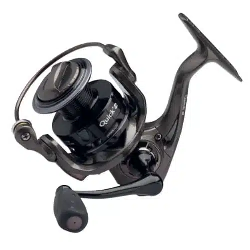 Primer plano de un carrete de pesca giratorio negro con un mango en el lateral. El carrete Carrete Dam Quick 2 6000 FD 340m/0,35mm, que presenta componentes metálicos y una bobina en el centro con la marca "Quick", ofrece un diseño elegante y moderno con un acabado metálico y un mango ergonómico, capaz de contener un sedal de 340m/0,35mm.