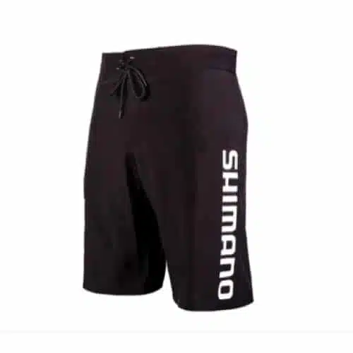 Los shorts de baño Shimano BS19002 tienen una cintura con cordón y la palabra "SHIMANO" impresa verticalmente en blanco en el lado izquierdo. Estos shorts negros versátiles son perfectos para usar con ropa deportiva o informal.