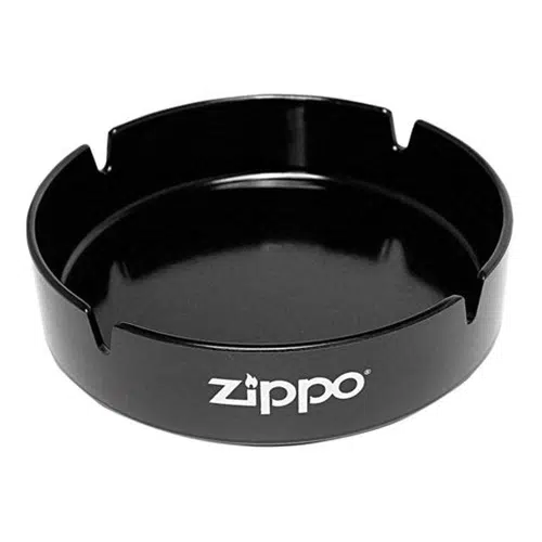 El cenicero Zippo Black cuenta con un elegante diseño circular en color negro y cuenta con cuatro prácticos soportes para cigarrillos. El lateral está elegantemente adornado con la palabra "Zippo" en blanco, rematado con un pequeño logotipo de llama sobre la "i".