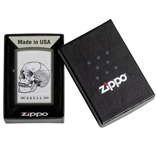 El encendedor Zippo Skull Design se presenta en una caja negra abierta que muestra el logotipo de Zippo. La tapa de la caja se encuentra adyacente, resaltando el grabado detallado en el encendedor con la palabra "Made in USA" elegantemente ubicada sobre el diseño de la calavera.
