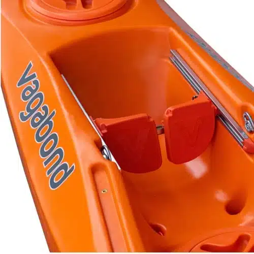 Primer plano de un kayak Marimba Vagabond de color naranja intenso con el nombre "Vagabond" claramente visible. La imagen resalta el área del asiento, con reposapiés ajustables que resaltan el diseño elegante y el color llamativo del kayak.
