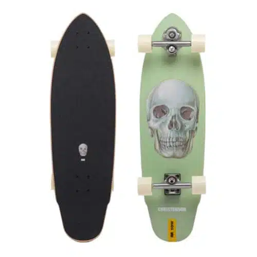 Se muestran dos vistas del Surfskate Lan Splitter 34” Christenson YOW. La vista inferior de la izquierda muestra una cinta de agarre negra con un pequeño gráfico de calavera en el centro. La vista superior de la derecha muestra una tabla verde pálido con un gráfico de calavera grande y detallado, que recuerda a los diseños de Surfskate de Christenson.