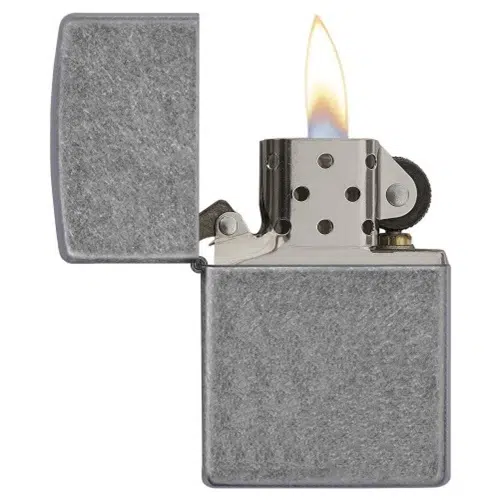 Un encendedor Zippo Classic Antique Silver Plate metálico presenta una superficie texturizada gris, una llama abierta, una parte superior cromada con orificios de ventilación y una rueda de encendido, que combina un estilo atemporal con una funcionalidad confiable.