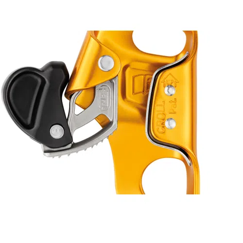 Primer plano del bloqueador ventral Petzl Croll S, un bloqueador de escalada dorado y negro con componentes plateados. Cuenta con una leva dentada y una empuñadura de agarre, diseñada para un movimiento ascendente seguro con cuerdas, lo que lo hace perfecto para quienes necesitan un equipo de escalada confiable.