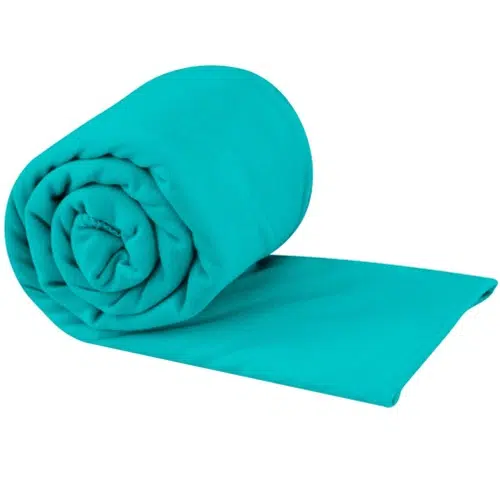 Una manta polar Sea To Summit de color turquesa brillante, cuidadosamente enrollada sobre un fondo blanco, que se asemeja a la eficiencia compacta de una toalla de bolsillo.