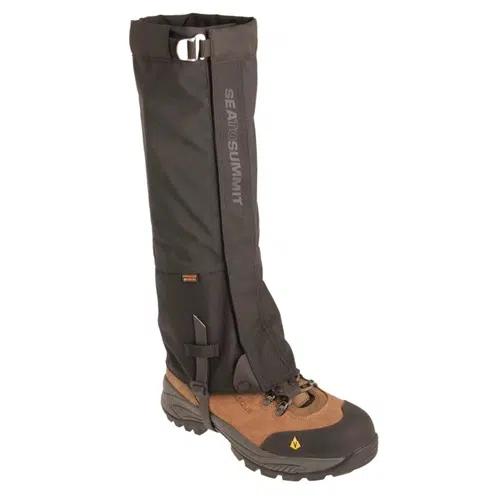 Una bota de senderismo de caña alta con un diseño de cuero marrón y tela negra se complementa con las polainas Sea To Summit Quagmire Gaiters eVent (SIN PFC) M Black de Polainas. Estas polainas se extienden hacia arriba y se aseguran con una hebilla en la parte superior. Cuentan con tecnología eVent duradera, lo que las hace ideales para uso en exteriores exigentes, y la marca "Sea to Summit" está impresa en la polaina.