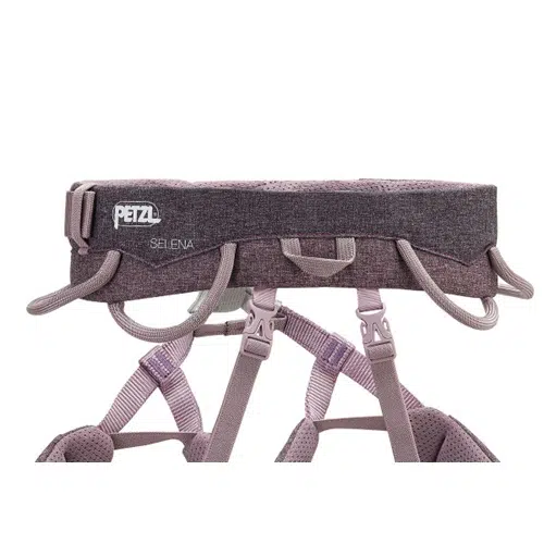 Primer plano del arnés de escalada Arnés Petzl Selena en color violeta, que muestra sus correas ajustables, portamateriales y presillas acolchadas en cintura y piernas, todo ello diseñado para mejorar la comodidad y la seguridad durante las actividades de escalada.