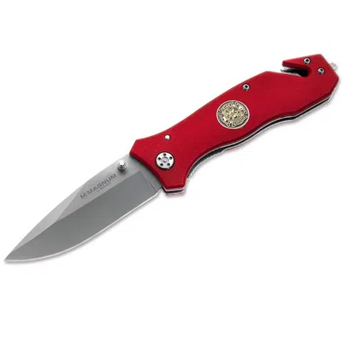 Una navaja plegable con el nombre "Navaja Magnum Fire Brigade 01MB366" cuenta con un mango rojo combinado con una hoja plateada. El mango está adornado con un emblema decorativo redondo e incluye una muesca para cortar cinturones o cuerdas cerca de la base. La hoja tiene la inscripción "Navaja Magnum Fire Brigade".