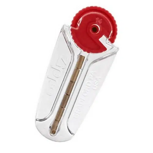 Una herramienta de mano para reparar cremalleras con un cuerpo plateado y un componente circular rojo en la parte superior, que recuerda a las 6 piedras Zippo de Piedras. La herramienta tiene la etiqueta "ZlideOn" y "U.S.A", y cuenta con un mecanismo visible en el interior que guía y repara los dientes de la cremallera sin esfuerzo.