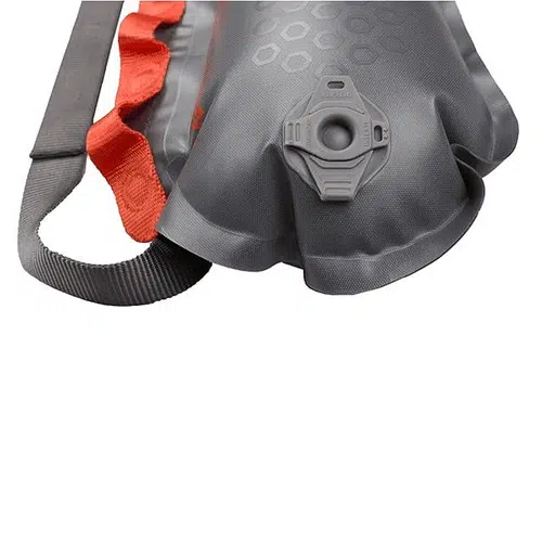 En esta imagen, puedes ver un primer plano del portaequipajes Sea To Summit en gris, acentuado con un borde rojo y una correa negra. Presenta un patrón hexagonal distintivo e incluye una tapa giratoria grande para facilitar el llenado y la limpieza, lo que lo convierte en el compañero ideal para tus aventuras en parrilla portaequipaje inflable.