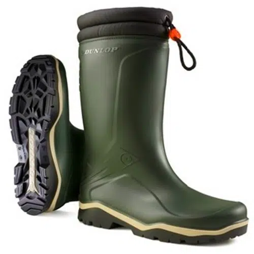 Un par de botas de goma Bota Dunlop Blizzard Fur Lining Verde con parte superior verde, suela negra y detalles en naranja. Una bota se mantiene en posición vertical mostrando el logotipo, mientras que la otra se encuentra de lado revelando el dibujo de la banda de rodadura en la suela. Las botas cuentan con un borde acolchado negro en la parte superior.