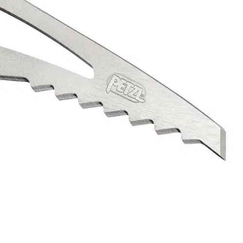 Un primer plano de la cabeza del piolet metálico Piolet Petzl Ride revela dientes dentados a lo largo de un borde y el logotipo de Petzl grabado en su superficie. El diseño incluye un corte triangular para reducir el peso.