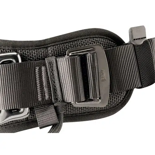 Primer plano del Arnés Industrial Petzl Avao Sit Fast Europeo, que muestra un cinturón táctico negro con una hebilla metálica resistente y una correa ajustable. Este arnés de estilo industrial cuenta con un acolchado texturizado para una mayor comodidad y durabilidad, cumpliendo con las normas de seguridad europeas.