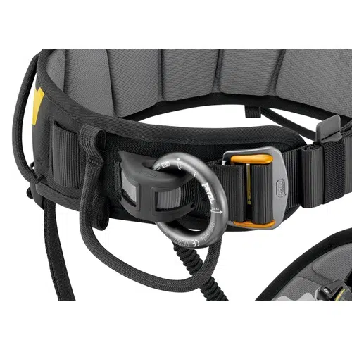 Primer plano del Arnés Industrial Falcon Petzl 2022, un arnés de escalada gris y negro equipado con un mosquetón metálico. Cuenta con secciones acolchadas y correas ajustables con hebilla, lo que enfatiza la seguridad y la comodidad.