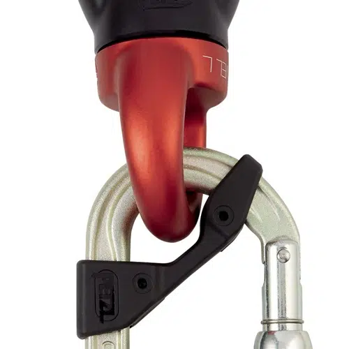 Primer plano de un gancho de escalada rojo conectado a un mosquetón Petzl Acero con mecanismo de cierre de rosca negro. El mosquetón está ligeramente abierto, lo que muestra la fijación segura. Este equipo Mosquetón Seguridad está diseñado para escalar o para asegurar.