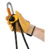 Una persona que lleva un guante amarillo agarra una cuerda de escalada negra y amarilla integrada con un Elemento de Amarre Industrial Petzl Progress Adjust -I, que cuenta con un mosquetón plateado con un seguro naranja y un sistema de poleas amarillo.
