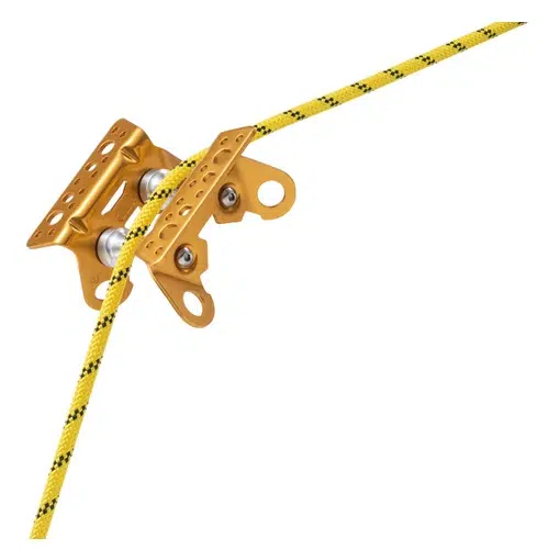 Una cuerda de escalada de color amarillo y negro se enhebra a través de un sistema de poleas metálicas con acabado dorado, similar al Protector para Cuerda Petzl Roller Coaster. Este dispositivo incluye múltiples orificios de fijación, dos ruedas visibles y parece estar destinado a fines de escalada o rescate.