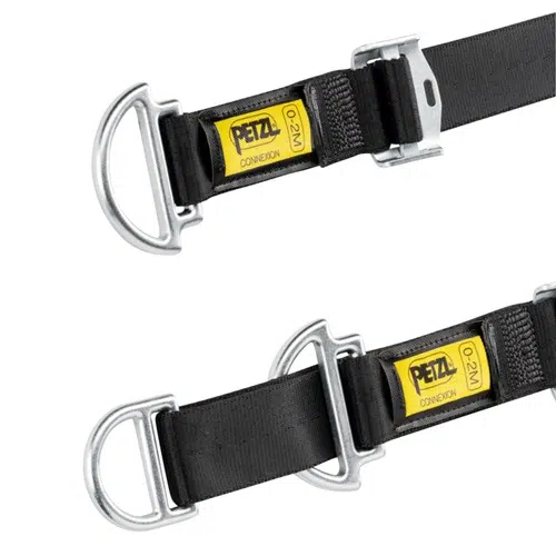 Primer plano de dos correas Petzl Connexion Vario en color negro, con anillas en D y hebillas metálicas. Cada correa está adornada con una etiqueta amarilla que muestra el nombre de la marca y el modelo, Anclaje Industrial Petzl Connexion Vario. La posición paralela resalta los detalles de los herrajes y las costuras.