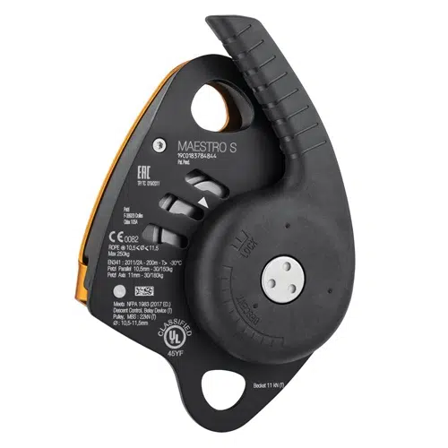 Primer plano de un Descensor de Rescate Maestro de Petzl en color negro y naranja, con marcas visibles y especificaciones técnicas. El dispositivo incluye un asa y un mecanismo de bloqueo, lo que garantiza seguridad y control en altura para los escaladores.
