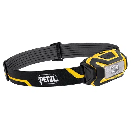 La Linterna Frontal Petzl Aria 1R 450lm es una linterna frontal negra con detalles en amarillo y gris, que cuenta con una elegante banda ajustable marcada con el logotipo "PETZL". La carcasa rectangular de la linterna tiene una lente transparente y una única luz LED central.