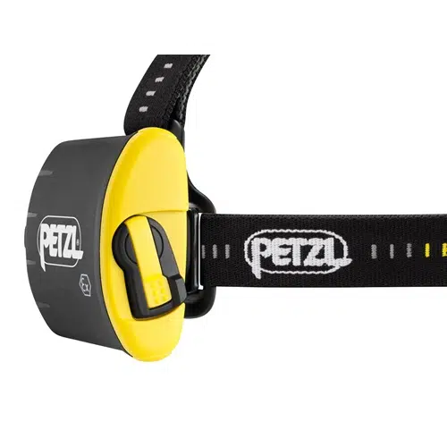 Primer plano de una linterna frontal negra y amarilla con una correa ajustable con el logotipo de Petzl. La Linterna Frontal Petzl Duo Z2 430lm cuenta con un botón prominente, perfecto para actividades al aire libre.
