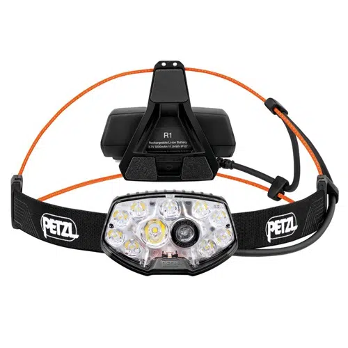 Presentamos la Linterna Frontal Petzl Nao RL 1500lm, una linterna frontal confiable que cuenta con múltiples luces LED y una elegante banda ajustable negra con el logotipo prominente de Petzl. Este diseño incluye un cable naranja que se conecta de manera eficiente a la batería, lo que la hace ideal para aventuras que exigen una iluminación constante.