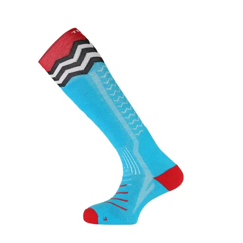 Medias de compresión hasta la rodilla Calcetín Teko Ecoski All-Mountain Medium Full Cushion en azul brillante, con detalles en rojo en la puntera y la parte superior, y un patrón en zigzag en negro, blanco y rojo cerca de la parte superior. La media también presenta patrones de costura blancos adicionales en toda su extensión.