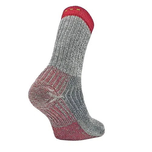 Un calcetín de lana gris y rojo de la colección Calcetín Teko Eco Trek 4.0 Merino Heavy Full Cushion se presenta sobre un fondo blanco liso. Este calcetín presenta un patrón de punto intrincado con detalles en rojo en la parte superior, el talón y la puntera, junto con dos pequeños puntos amarillos cerca del puño, perfecto para los entusiastas de Teko Eco Trek.