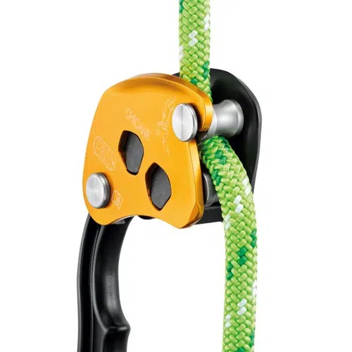 Primer plano de un Descensor Industrial Petzl Chicane amarillo con una cuerda verde y blanca enhebrada a través de él. Este descensor cuenta con componentes plateados y negros, diseñados para una manipulación segura de la cuerda, lo que lo hace ideal para operaciones de escalada o rescate.