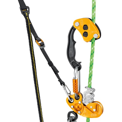 El equipo de escalada incluye un Sistema Petzl de Ascenso Knee Ascent Clip con un dispositivo de seguridad naranja y negro, mosquetones y una cuerda verde. El equipo está dispuesto verticalmente, mostrando su diseño y funcionalidad para escalada o seguridad.