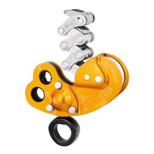 Presentamos el Descensor Industrial Petzl Zigzag Plus, un equipo de escalada de alta calidad que incorpora un bloqueador mecánico de color naranja y plata con un anillo negro en la parte inferior. Este dispositivo incluye múltiples componentes metálicos y ranuras para la fijación de cuerdas, lo que lo hace ideal para ascender por cuerdas tanto en escalada como en operaciones de rescate.