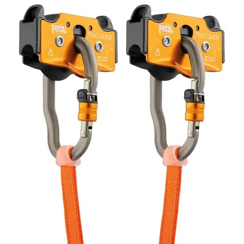 Dos sistemas de poleas Petzl Trac Guide de color naranja y negro con mosquetones grises y correas de color naranja. El diseño incluye cierres de seguridad. Se utilizan para actividades de tirolina o escalada.