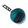 Una vista superior de una olla de cocina gris con un interior azul resalta su diseño práctico. En el interior, junto al mango negro plegable hecho de metal y plástico para un fácil almacenamiento, se encuentra una Espátula Plegable Sea To Summit Camp Kitchen Folding Spatula, ideal para cualquier cocina de campamento.